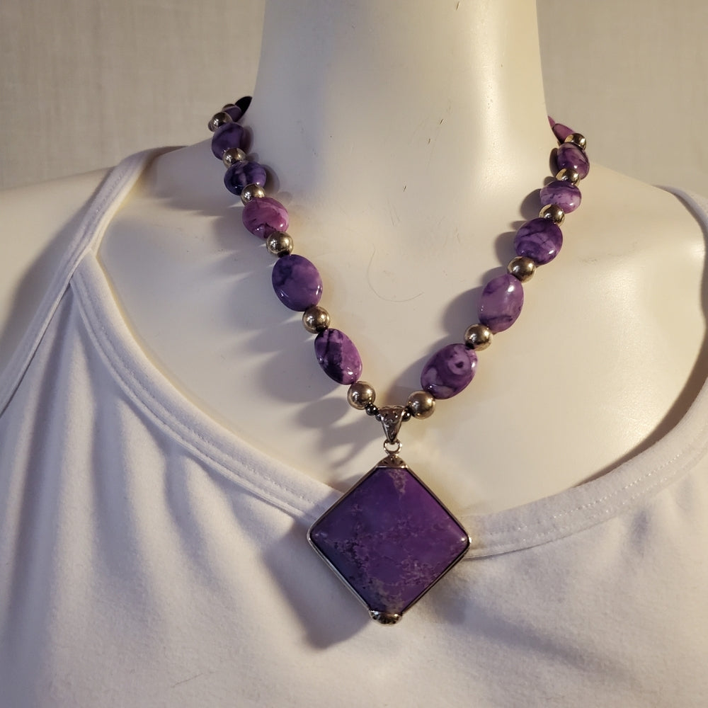 Purple stone bead necklace with square pendant.
