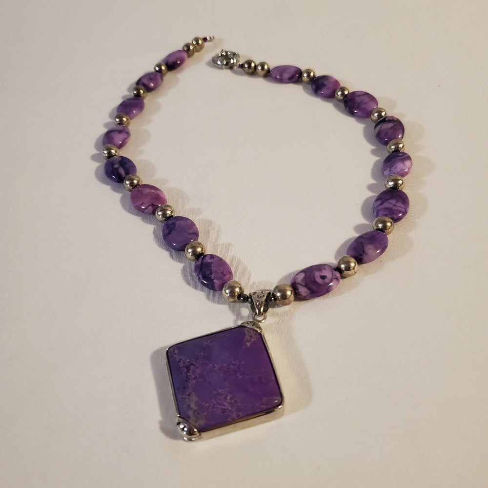 Purple stone bead necklace with square pendant.