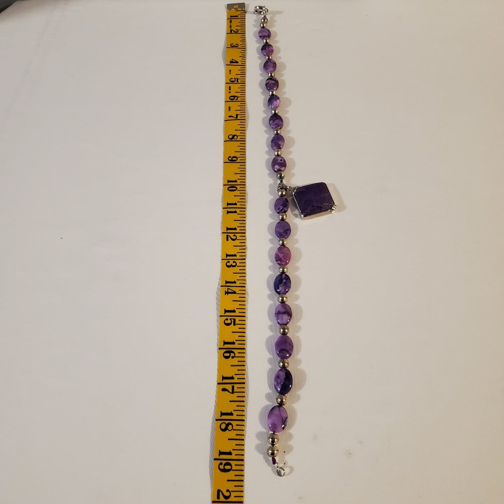 Purple stone bead necklace with square pendant.